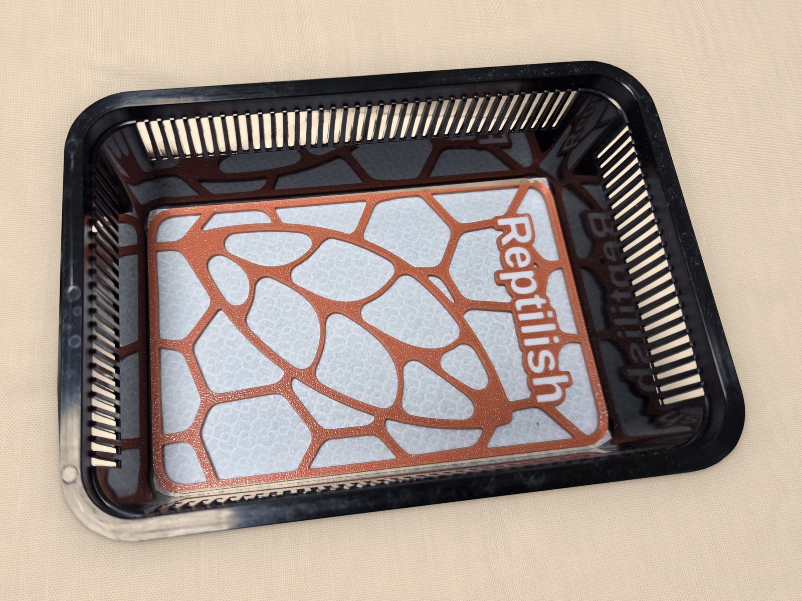 Una piastra Pebble Plate rettangolare in Terracotta, con testo personalizzato, appoggiata sul tappetino in un faunabox piccolo